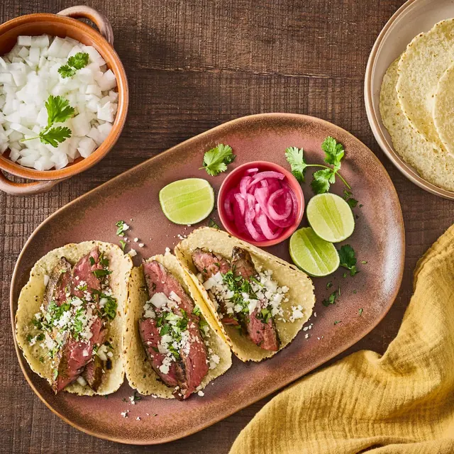 Steak tacos with fresh onion, cilantro and lime